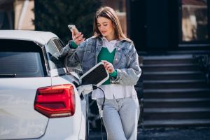 Woman charging her electric car with charging pistol